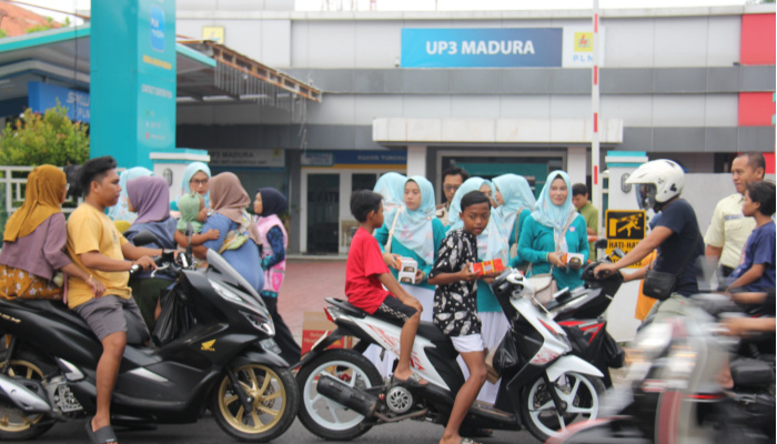 Anggota Srikandi dan PIKK PLN UP3 Madura membagikan takjil gratis kepada pengendara di depan Kantor PLN UP3 Madura, Pamekasan, Jumat (14/3/2025).