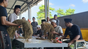 H. Mukmin (tengah songkok putih) bersama tim Perusahaan Rokok (PR) Bahagia saat melakukan sortir kualitas tembakau musim panen 2025. (Dok. JARAK.co)