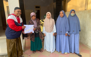 Simbolis : Wakil Ketua PWRI Sumenep, Subaidi Iksan membagikan mukena kepada guru ngaji.