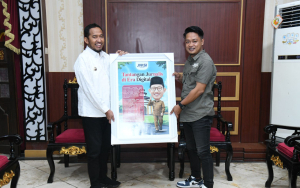 Ketua Jaringan Media Siber Indonesia (JMSI) Kabupaten Sumenep, Supanji saat memberikan cinderamata kepada Bupati Achmad Fauzi Wongsojudo. (Istimewa)