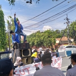 Puluhan mahasiswa PMII Komisariat UNIJA menyampaikan orasi di atas mobil komando saat menggelar aksi demonstrasi di depan Kantor BRI Cabang Sumenep, dikawal ketat aparat kepolisian. (Ist)
